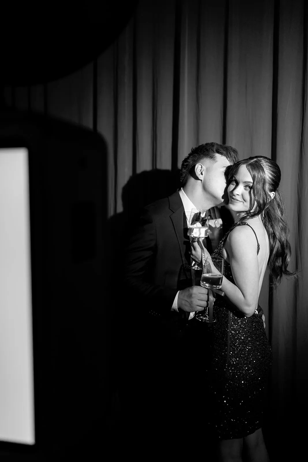Couple toasting beside the photo booth at a Boerne celebration